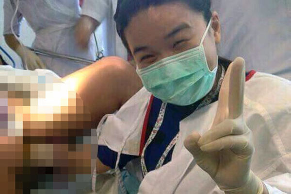 Bác sĩ giơ tay tạo dáng chụp ảnh khi đang đỡ đẻ