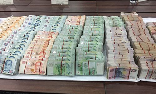 Số tiền mặt cảnh sát tịch thu từ hai nghi phạm. Ảnh: SPF