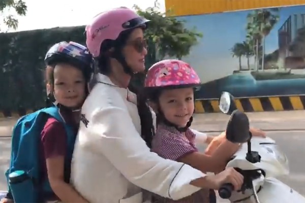  Hồng Nhung chở con đến trường bằng xe máy. 
