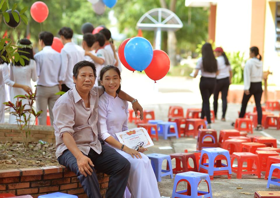 Nữ sinh trong bức ảnh 2 bố con dự lễ tổng kết năm học đang gây sốt : '10 năm nay, năm nào ba cũng cầm bóng bay đến chúc mừng con gái'