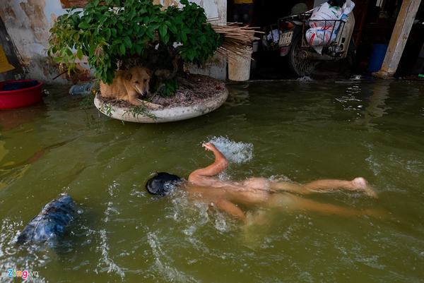 Hơn 800 hộ ở Hà Nội vẫn bị cô lập trong nước lũ, dân bơi trước cửa nhà